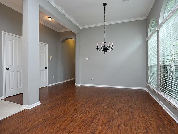 View of the dining room/living room combo when you enter the front door. Beautiful hardwood floors and crown molding throughout this home.