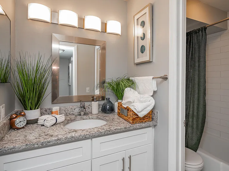 Bright bathroom with granite counters and bathtub