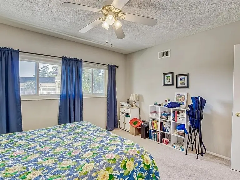 Guest bedroom with ceiling fan and closet space.

 *This unit is unfurnished. All furniture has been removed.