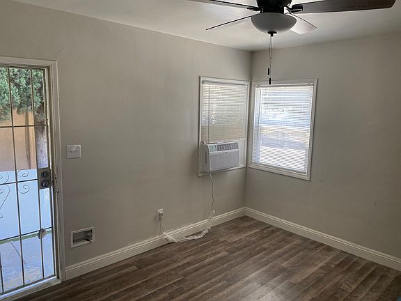 Living room with large wall a/c unit and new wood flooring