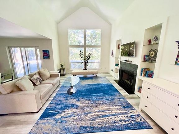 Large windows fill the room with natural light, making it the perfect space for relaxing or entertaining.