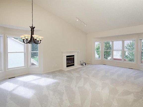 Large Great room with dining area & fireplace. Note the beautiful triple bay window in living area and bay window in dining area. Vaulted ceilings too!