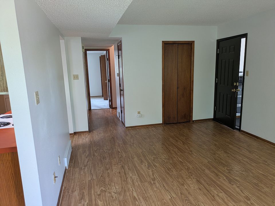Front door on right, view down hallway, coat closet and 2 closets in hallway. Vinyl plank flooring