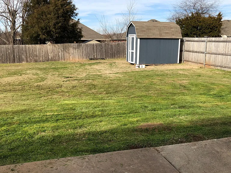 Large back yard with storage shed.