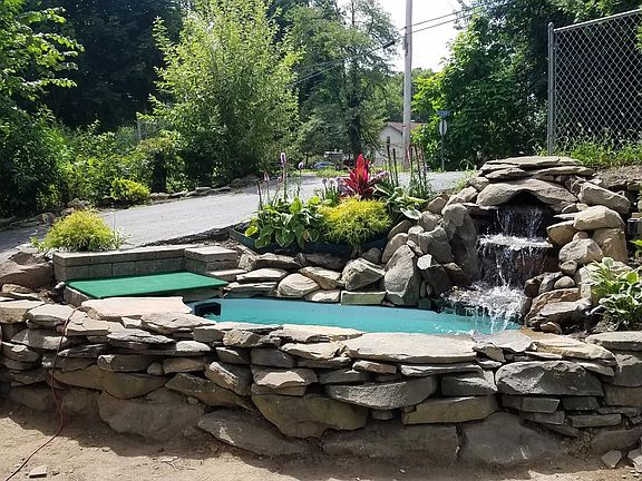 Koi pond With waterfall at top of driveway with small patio to relax on