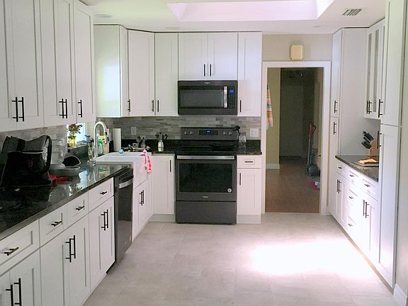 Kitchen - all appliances just 2 years old and granite counters! Lovely light space with natural light and very high ceiling (above section from which photo was taken).