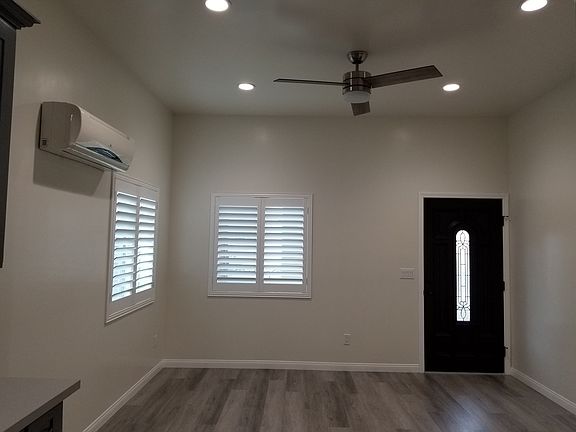 open space living room with ductless mini split and new ceiling fan. 10 feet high ceiling