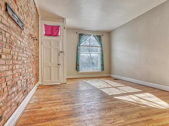 SPACIOUS LIVING RM w/WOOD FLRS & BRICK ACCENT WALL