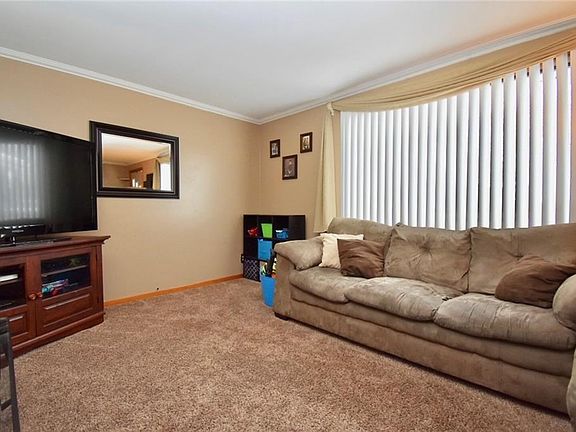 The living room measures 20x12. Hardwood floors are underneath carpeting in living room and 3 bedrooms on main floor.