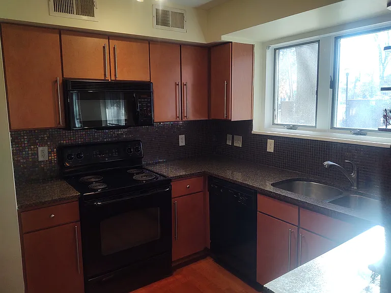Kitchen with granite counters and maple cabinets.