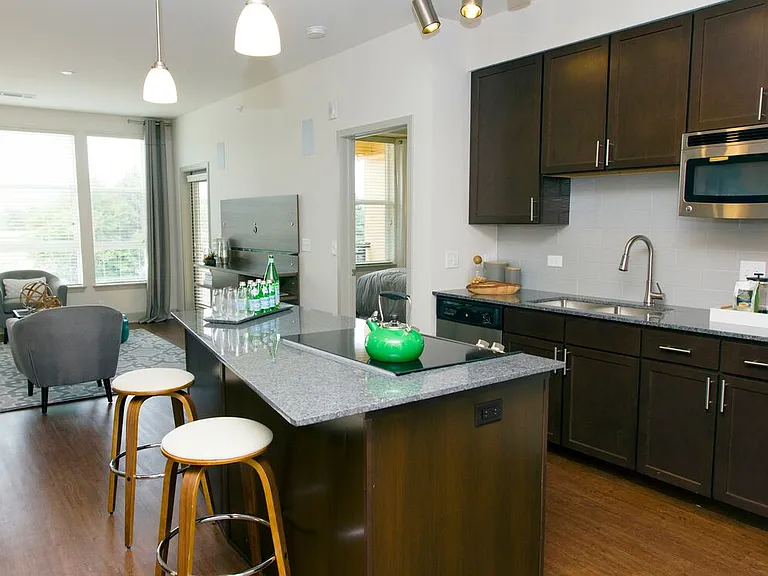 Classic Package kitchen with espresso cabinetry, speckled granite countertops, grey subway tile backsplash, stainless steel appliances, and hard surface flooring