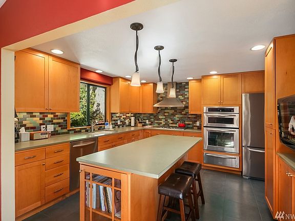 Remodeled kitchen with stainless steel appliances, gorgeous tilework, quartz counters, gas range, oven with warming drawer, and built-in microwave. Ample storage in the maple cabinetry. (TV goes with Seller.)