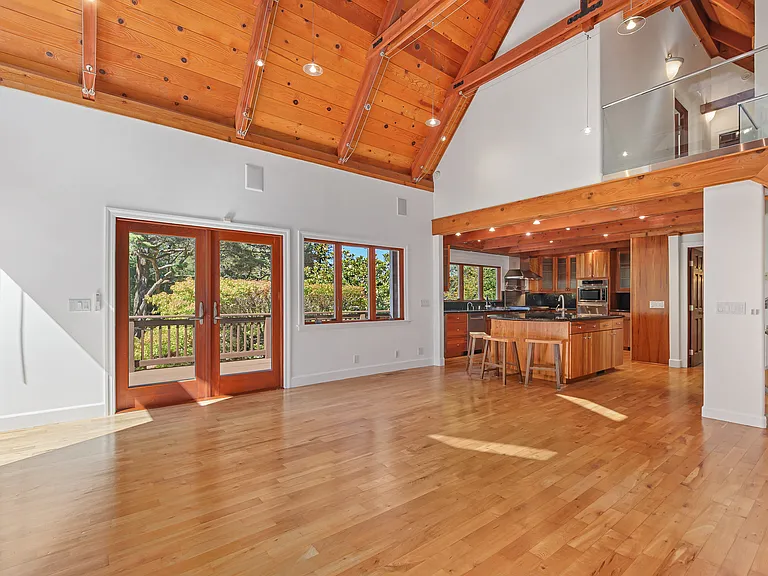 Living room with chef's kitchen in background. Direct access to wrap-around deck. Wonderful for entertaining.