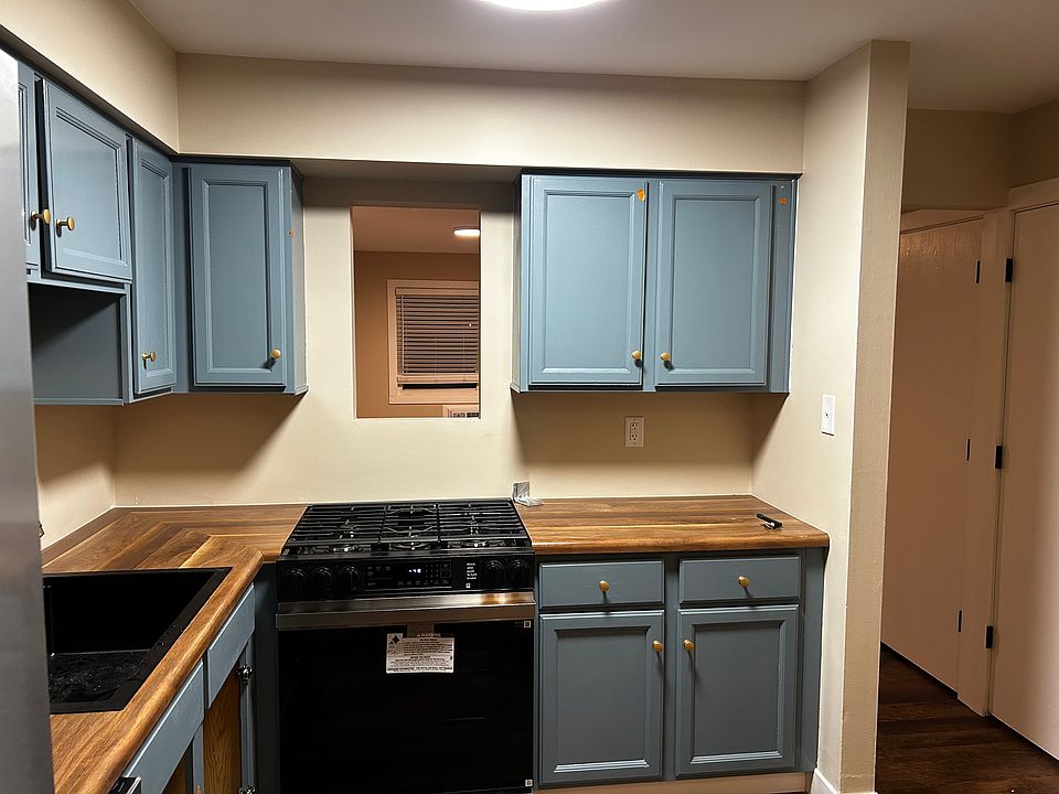 You can see the entire living room and front bedroom standing in front of the stove / range looking through the window between the cabinets