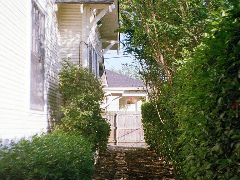 View of side private garden and lovely walking paths. This home is completely fenced and hosts private spaces.out doors.