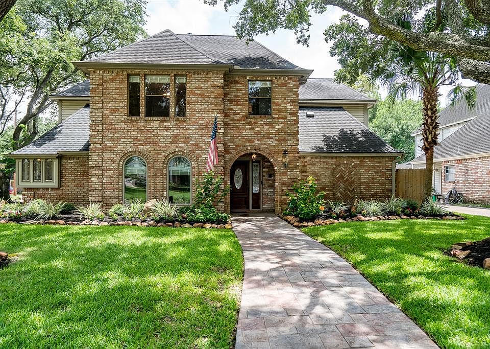 This charming home beckons visitors from the street. Stately and clad in brick with expansive windows.