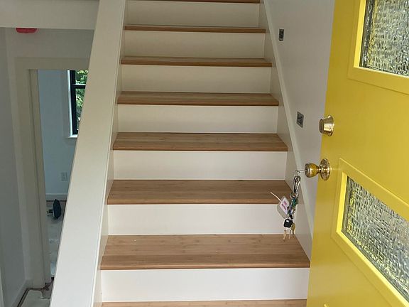 Stairway from front door up to living area and kitchen. 2 Bedrooms & bath are below.