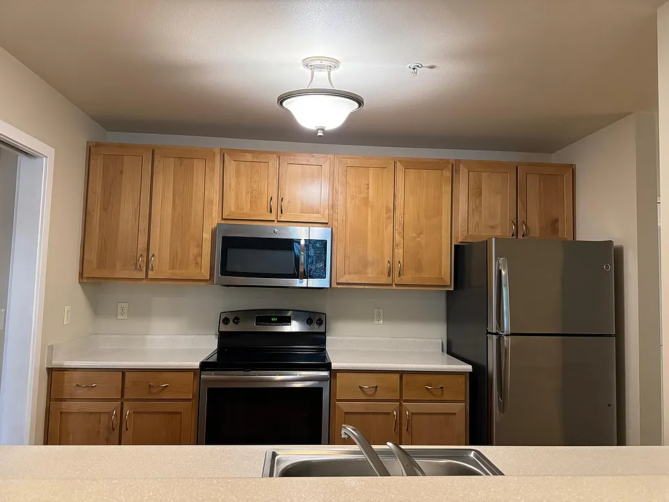 Kitchen view with stainless appliances and natural wood
