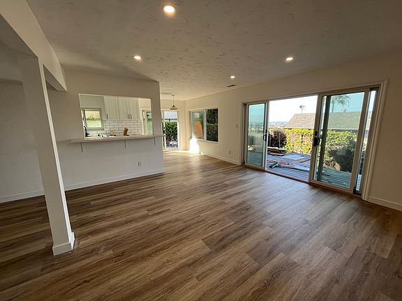 Living room leading to outdoor deck and kitchen / bar
