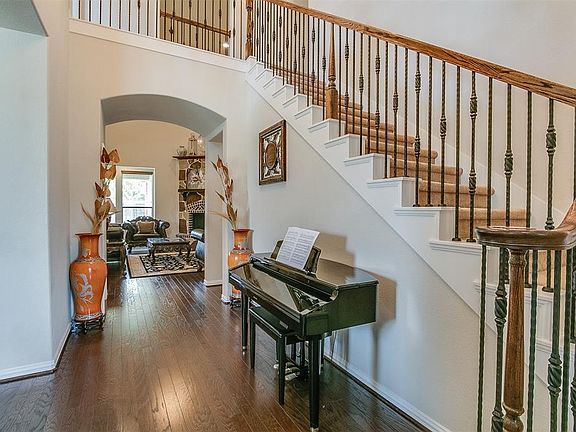 The light and bright entry boasts gleaming hardwoods and soaring ceilings with a beautiful wood and iron spindled stairway that leads to the second floor.