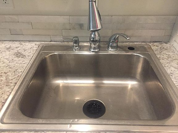 Huge kitchen sink with granite and backsplash