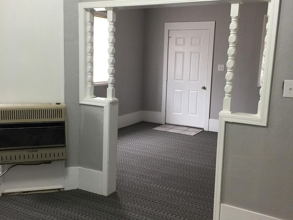 Dining room has gas wall heater and window AC. View into li