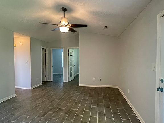 Living area and 2nd, 3rd bedroom doors looking from dinning area and door to backyard.