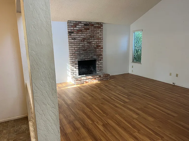 The family/entertaining room features a brick wood fireplace and a wet bar.