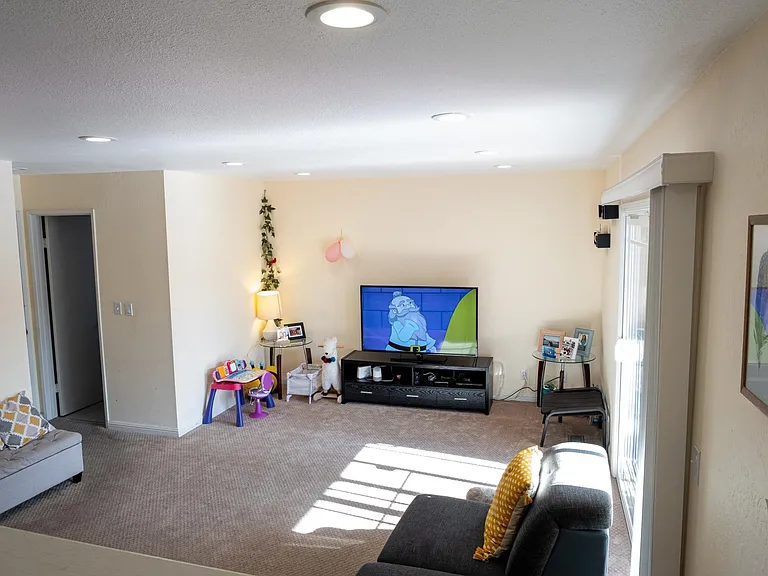 Family room with carpets before which have now been replaced with wooden flooring