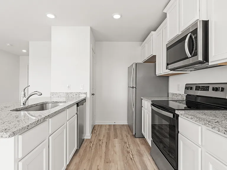 Kitchen with white cabinets and granite countertops.