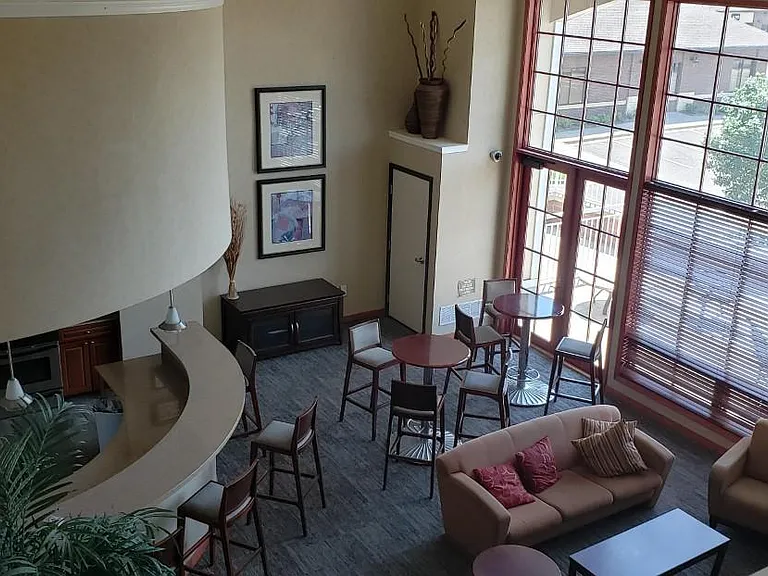 View from balcony into the partyroom shows the wall of windows giving a well lighted ambiance and a peak at the outdoor patio