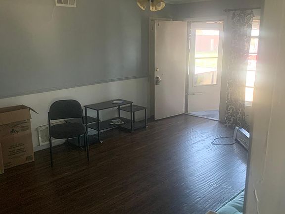 Cross view of Living Room toward Front Door. Shows off Newly Re-Conditioned hardwood floors throughout. The living room also has a new ceiling fan