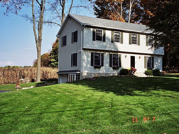 Left side of house w/one car attached garage. Note corn field in back.