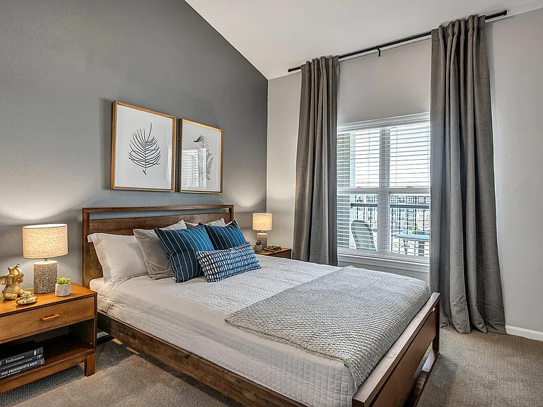 Large windows with natural light, vaulted ceilings, and lush carpeting are bedroom features available at Kinsley Forest Apartments.