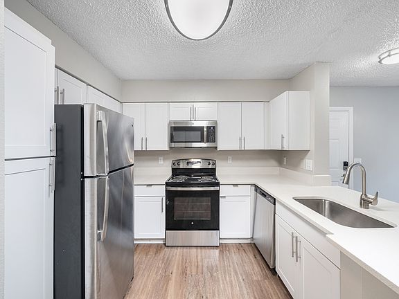 Cook and entertain with ease in a stylish kitchen featuring sleek appliances, granite-inspired countertops, and contemporary details throughout