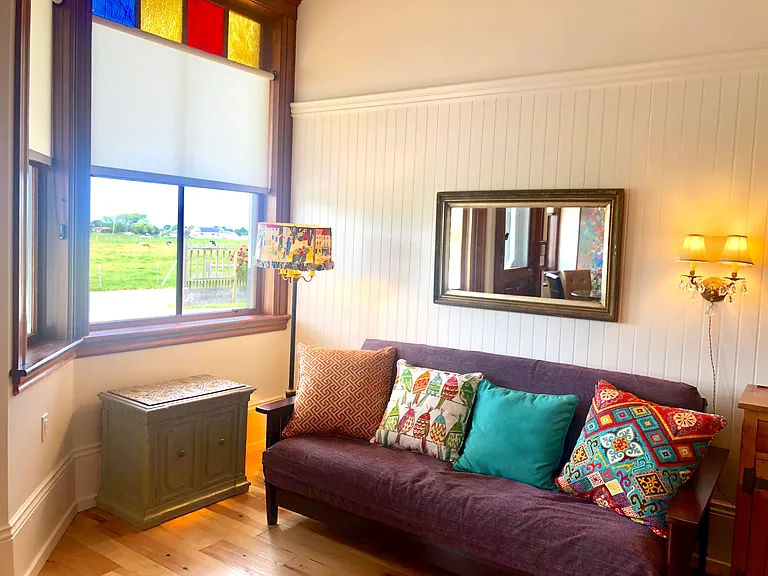 Cozy and stylish futon couch folds out into a comfortable full-size bed with high-quality mattress. Watch our smart T.V. from your bed, breakfast bar, or glass table!