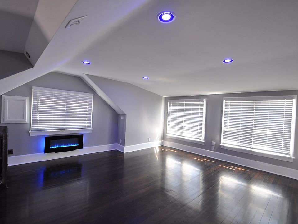 Charming living room with chic electric fireplace, real Douglas Fir hardwood floors, big, bright windows, and dimmable / programmable Philips Hue Smart lighting