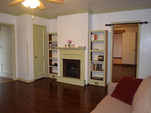 Living room with built in shelves and original hardwood floors.
