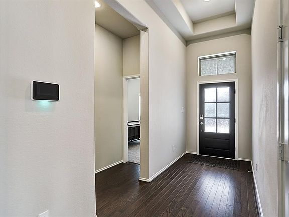 The extended entry features a tray ceiling and gorgeous wood floors.