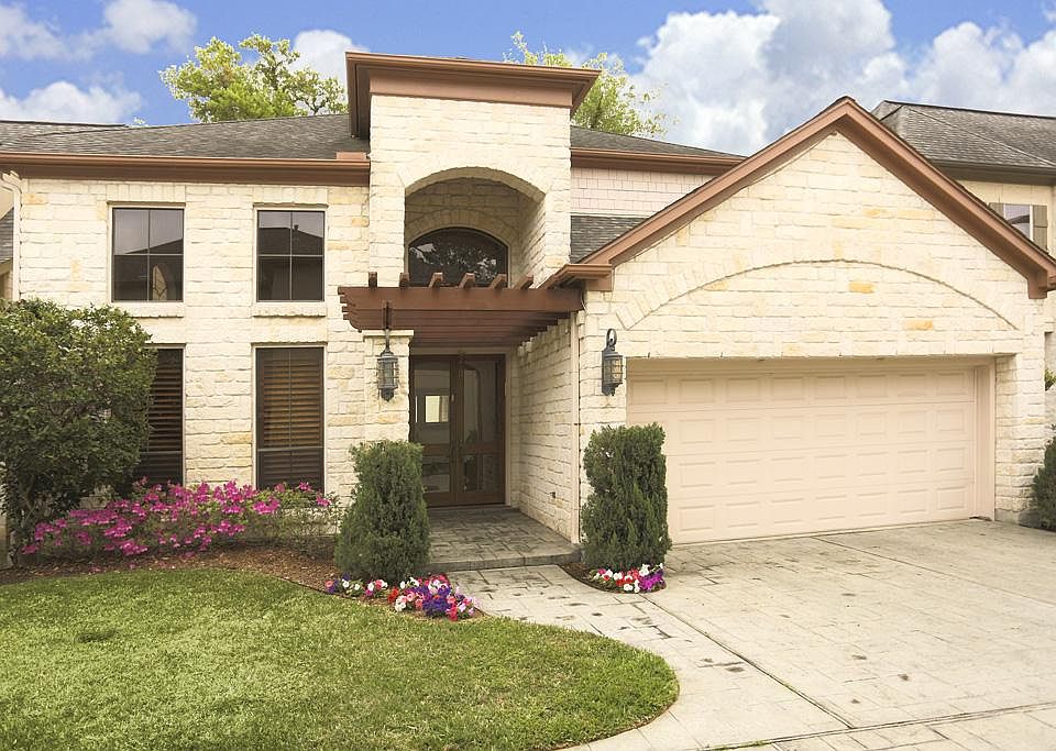 Front view with limestone and cedar trellis framing entry way.