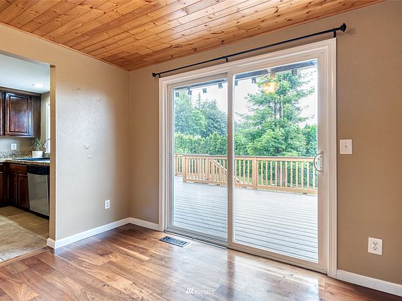 The dining room with knotty pine paneled ceiling is adjacent to the kitchen for easy meals from cooktop to dining table. A slider opens to your new composite deck and sprawling backyard.