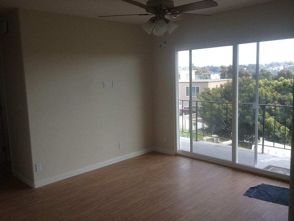 living room with sliding glass door; plenty of natural light from south facing balcony; easy-to-clean laminate floors