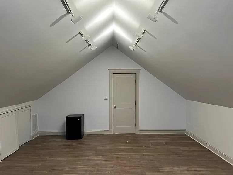 Room looking towards the entry door. Small fridge shows comes with the room.
