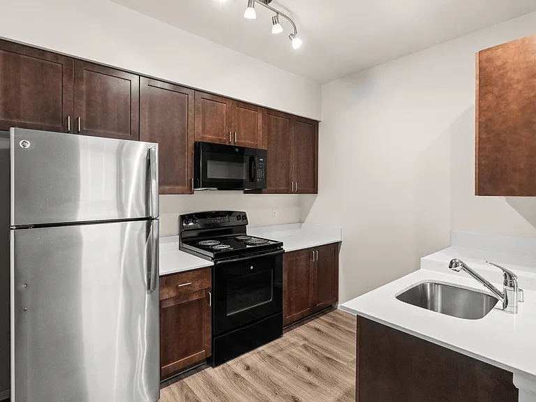 Enjoy a sleek, modern kitchen featuring stainless steel appliances, rich wood cabinetry, and bright countertops. Enjoy a sleek, modern kitchen featuring stainless steel appliances, rich wood cabinetry, and bright countertops.
