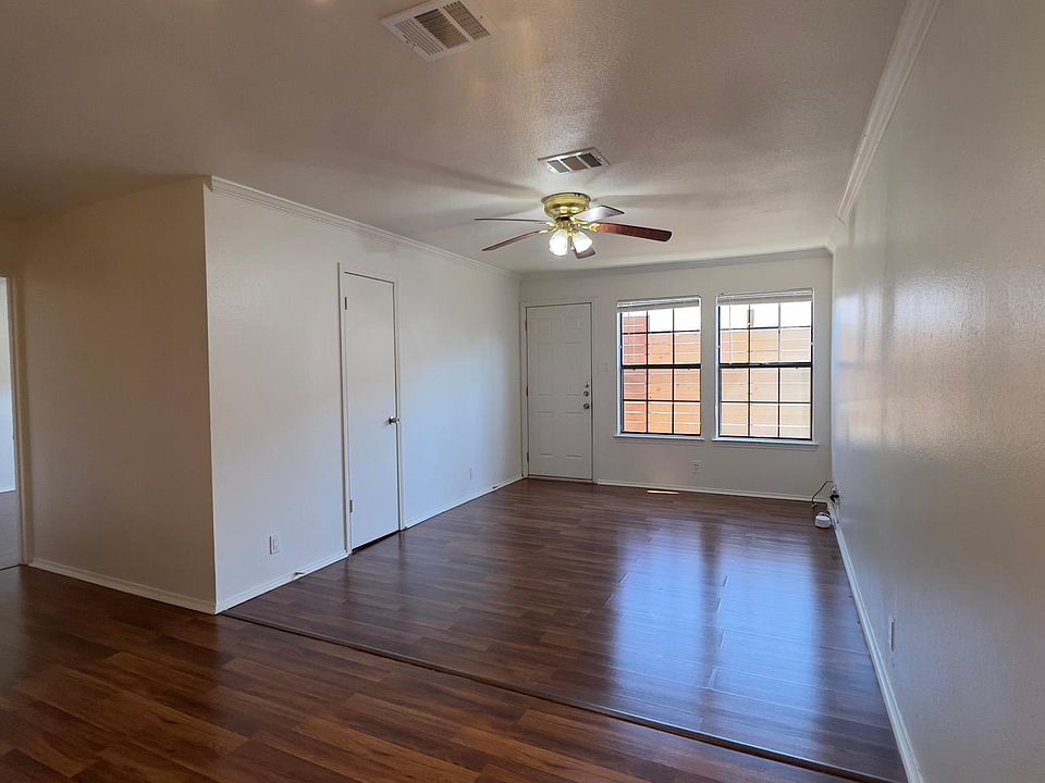 View from dining area towards the living room, a small storage room and the hallway leading to the primary bedroom.