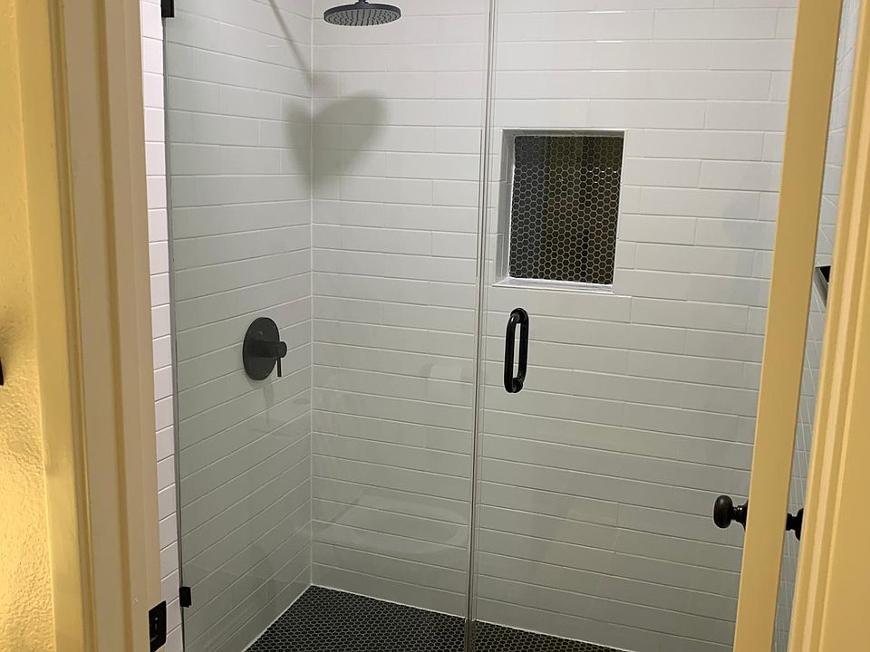 remodeled shower w sleek glass door.