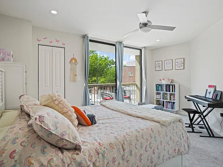 Large, bright secondary bedroom featuring ample closet space and convenient private balcony access