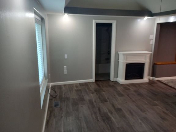 looking from front door across living room that includes electric fire place