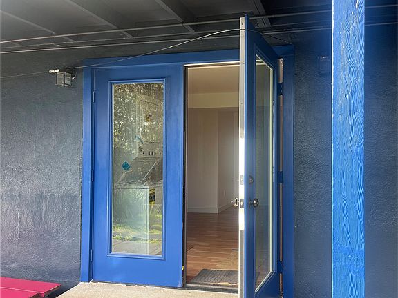 Double French door entrance to rental unit. Facing Garden with morning light.