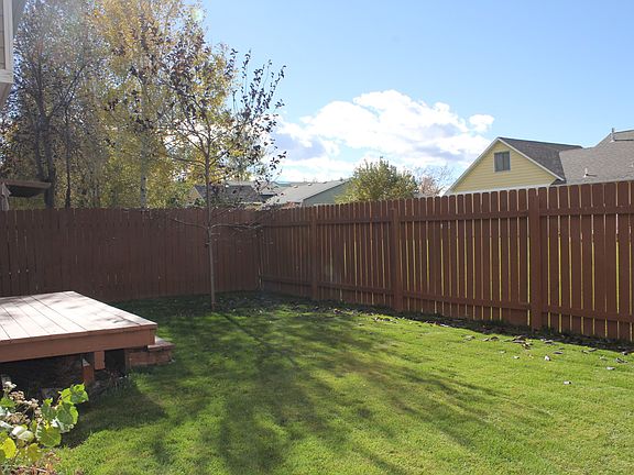 Fully fenced backyard with side gate, underground sprinklers, trex deck, mature tree.